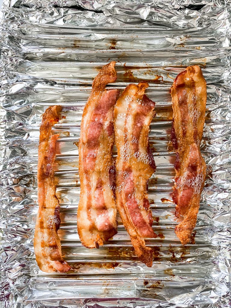 bacon cooking in the oven on tinfoil