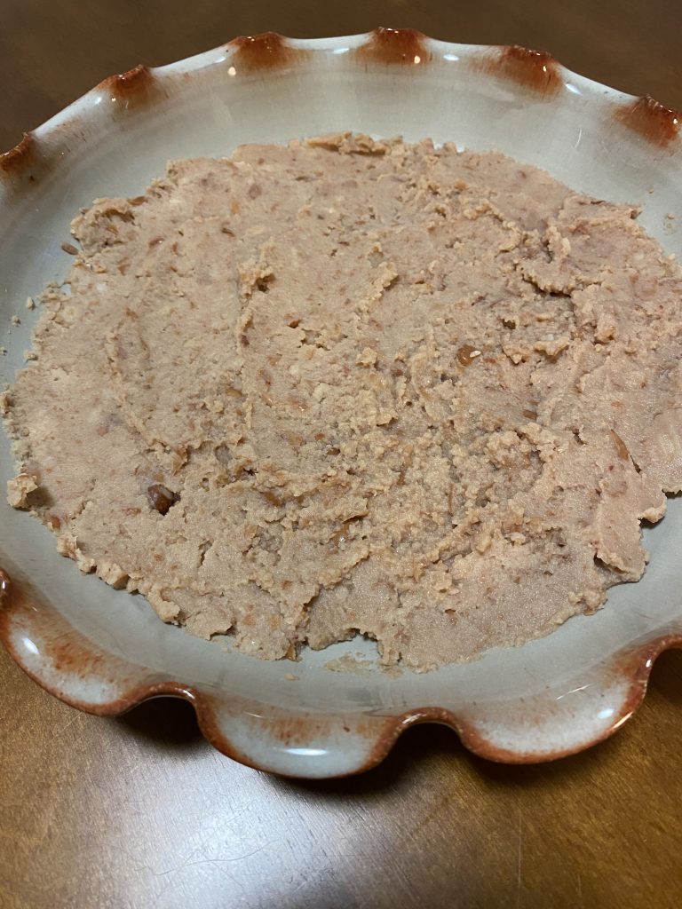 refried beans at bottom of dish 