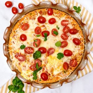 Baked eggs topped with cheese and cherry tomatoes