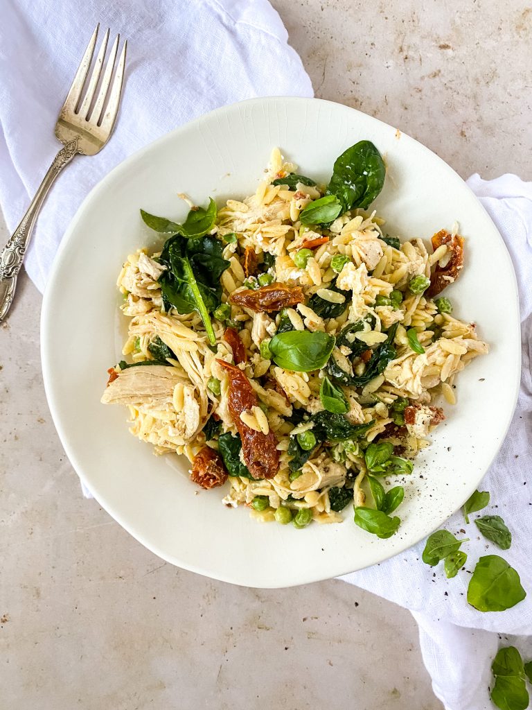 pasta salad in a bowl with a fork on the side