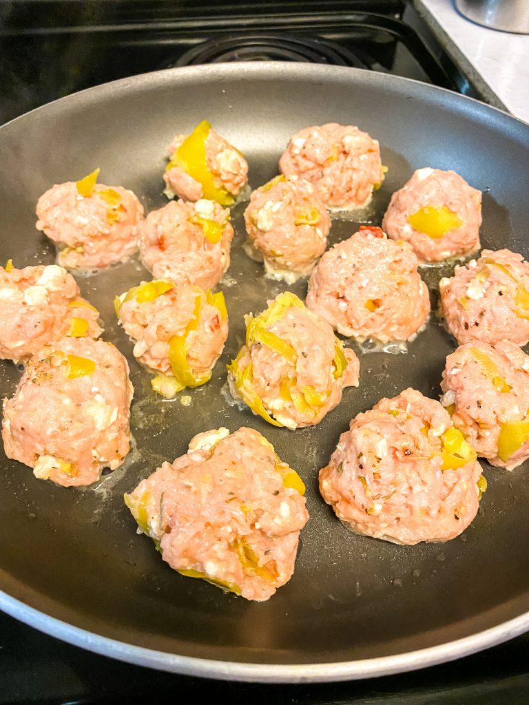 Cooking chicken meatballs in a pan 