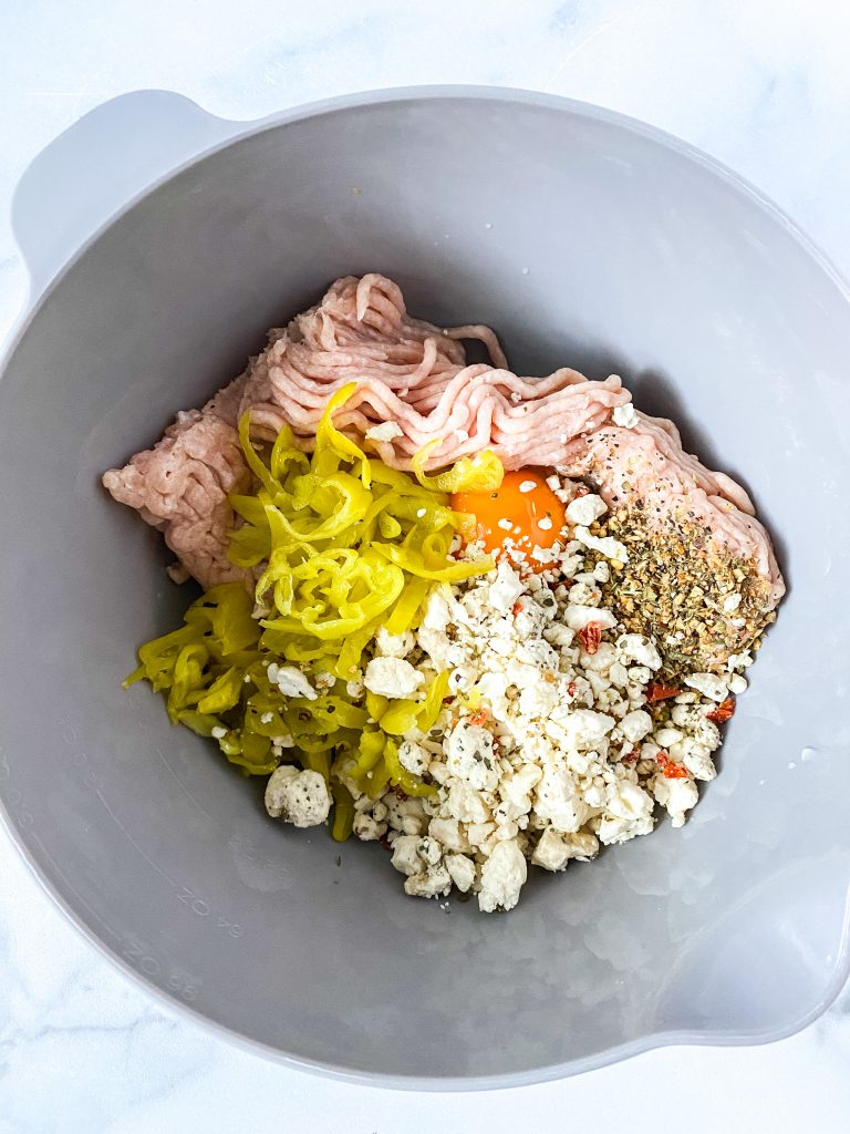 a mixing bowl with all ingredients for greek meatballs 