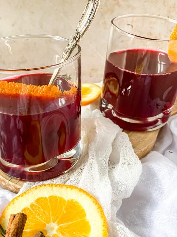 2 glasses of german mulled wine on a cutting board with orange slices