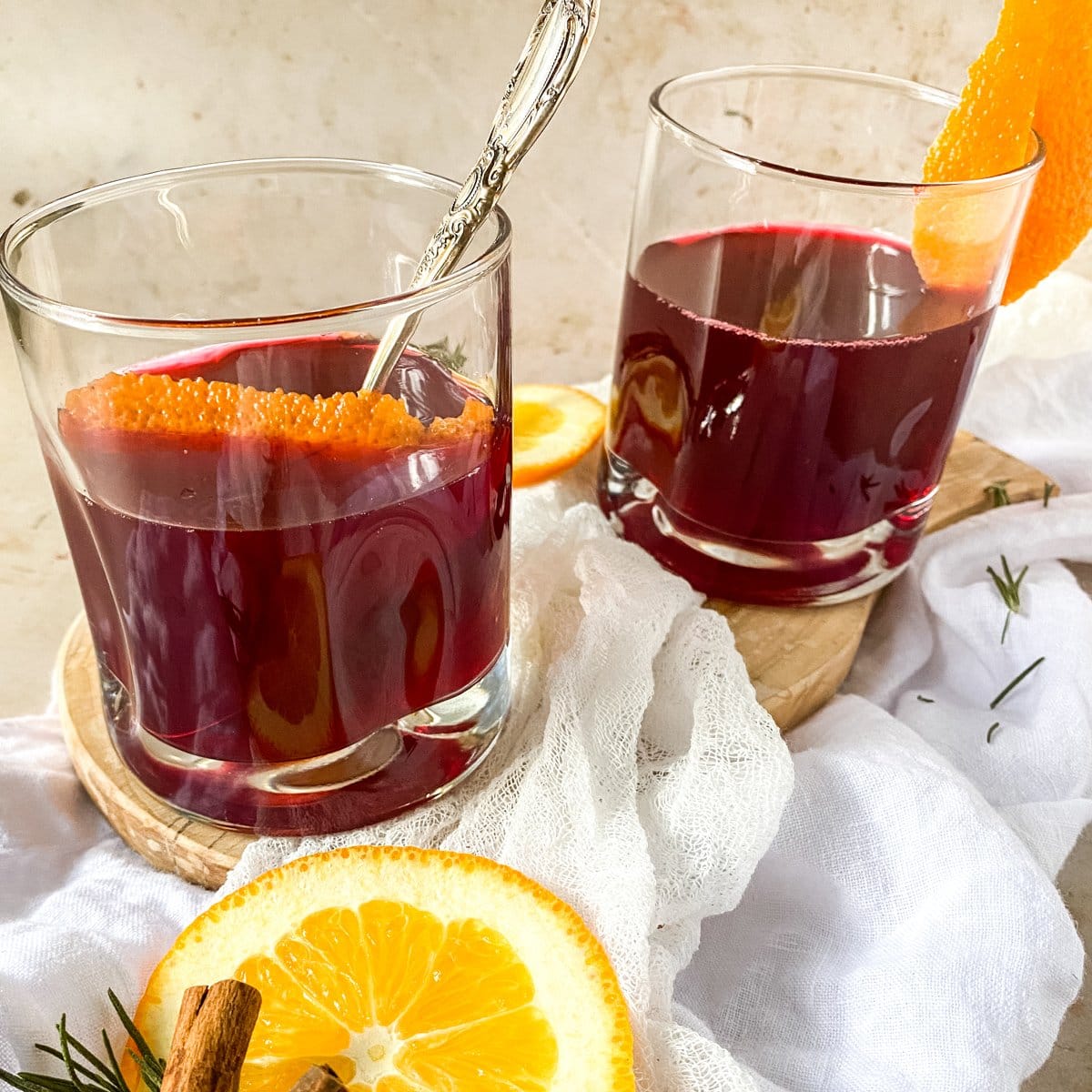2 glasses of german mulled wine on a cutting board with orange slices
