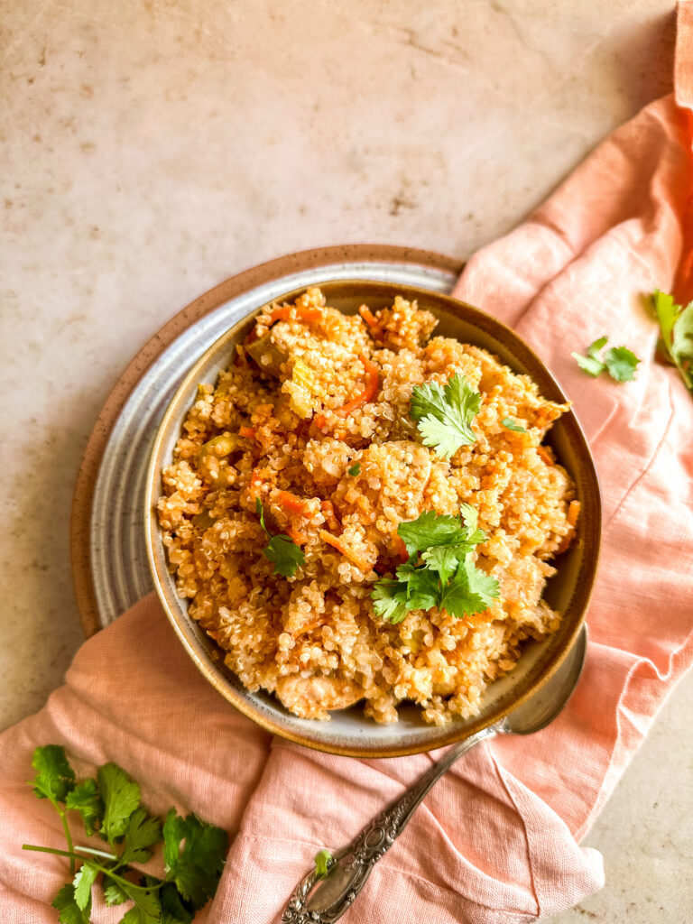 a pink background with a bowl of buffalo chicken casserole