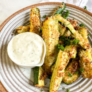 a bowl of air fryer zucchini with ranch dipping sauce