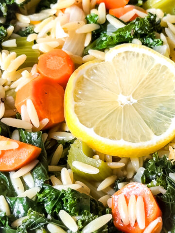 A close up of orzo, carrots, kale, celery and lemon