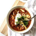 a bowl of enchilada soup topped with greek yogurt