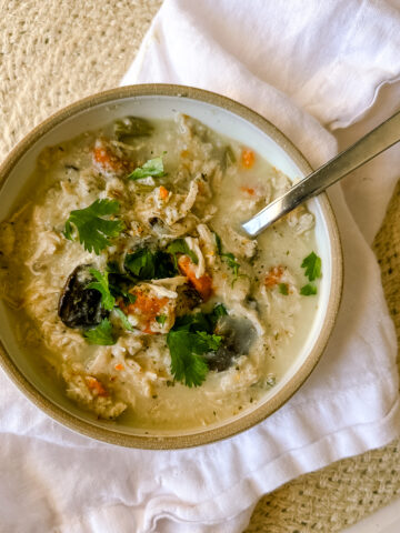 a bowl of chicken soup on a white napkin