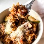 a fork scooping a bite of orzo with zucchini