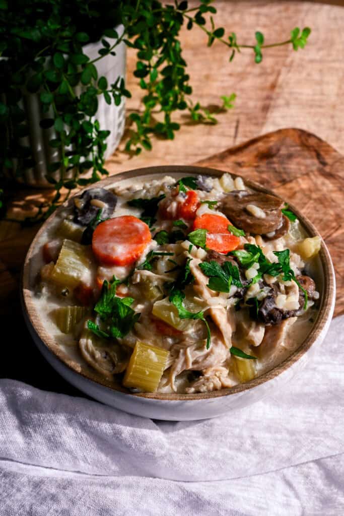 a bowl of dairy free chicken and wild rice soup on a cutting board