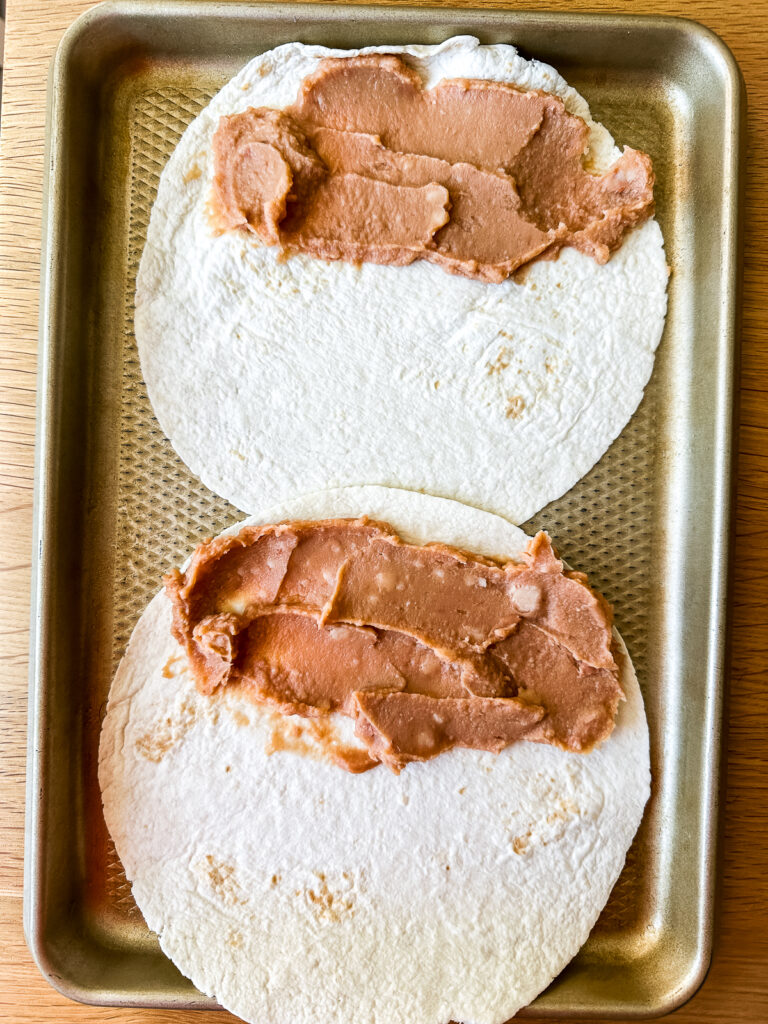 spreading beans on tortillas