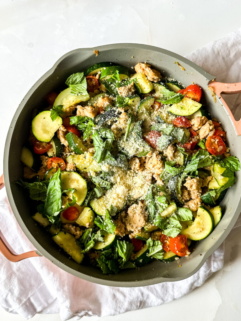 A pan filled with zucchini and sausage.
