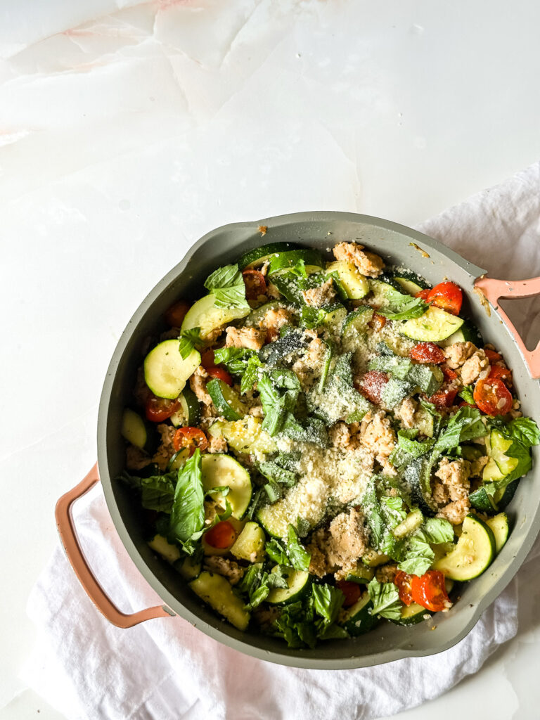 A pan filled with zucchini and sausage.