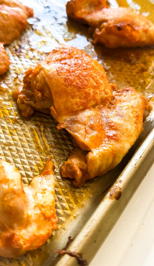 Baked buffalo chicken thighs on a sheetpan