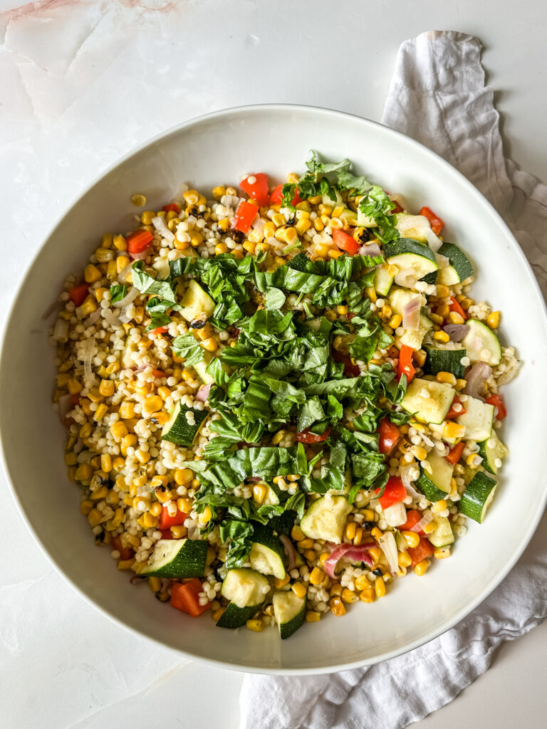 couscous salad with summer veggies in a white bowl