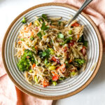 a bowl of sesame noodles with vegetables