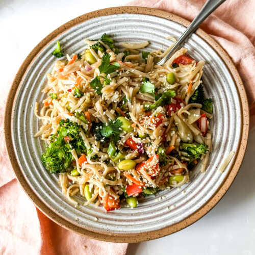 a bowl of sesame noodles with vegetables
